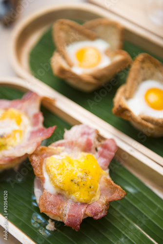 baked egg in bacon bowl on wooden tray