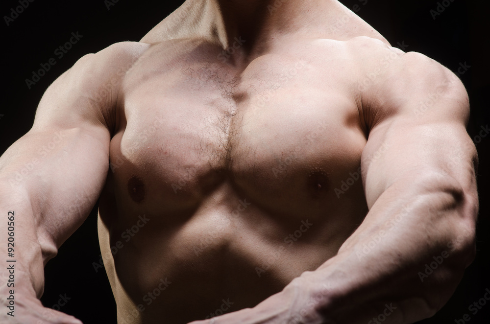 Fototapeta premium Muscular man posing in dark studio
