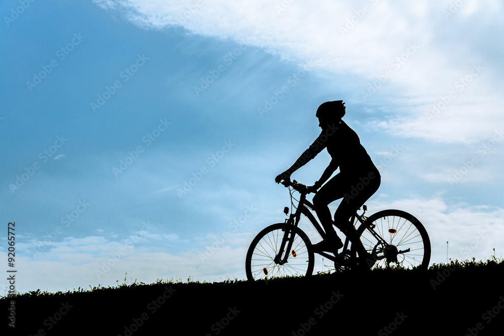 Silhouette of the cyclist riding a mountain bike.