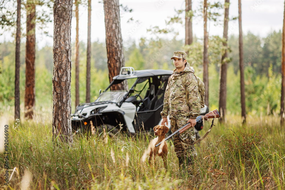 Hunter with Rifle and Four Wheeler Tire in forest Hunter with Rifle and Four Wheeler Tire in forest