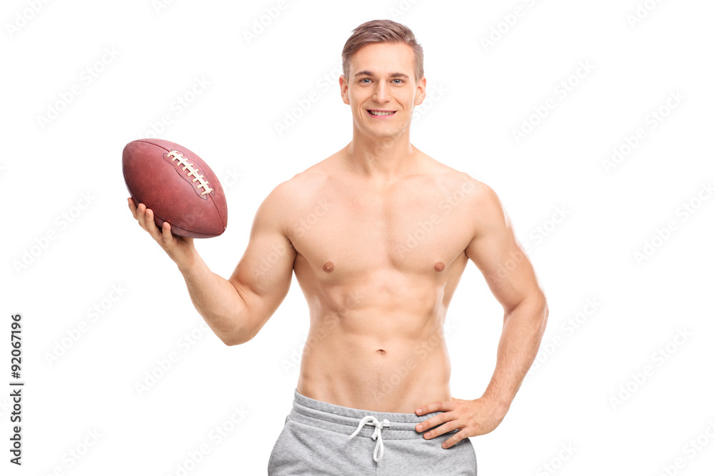 Shirtless young man holding a football Shirtless young man holding a football