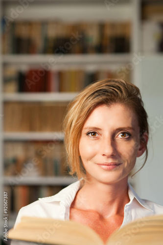 Woman with book in home library