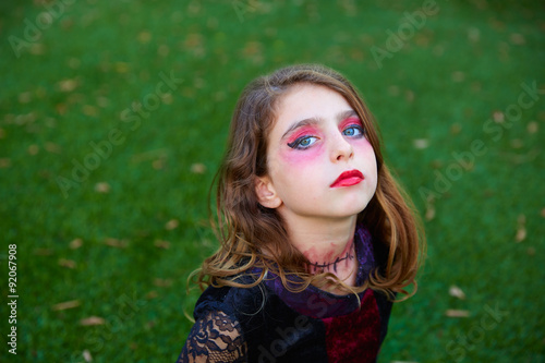 Halloween makeup kid girl blue eyes in outdoor lawn