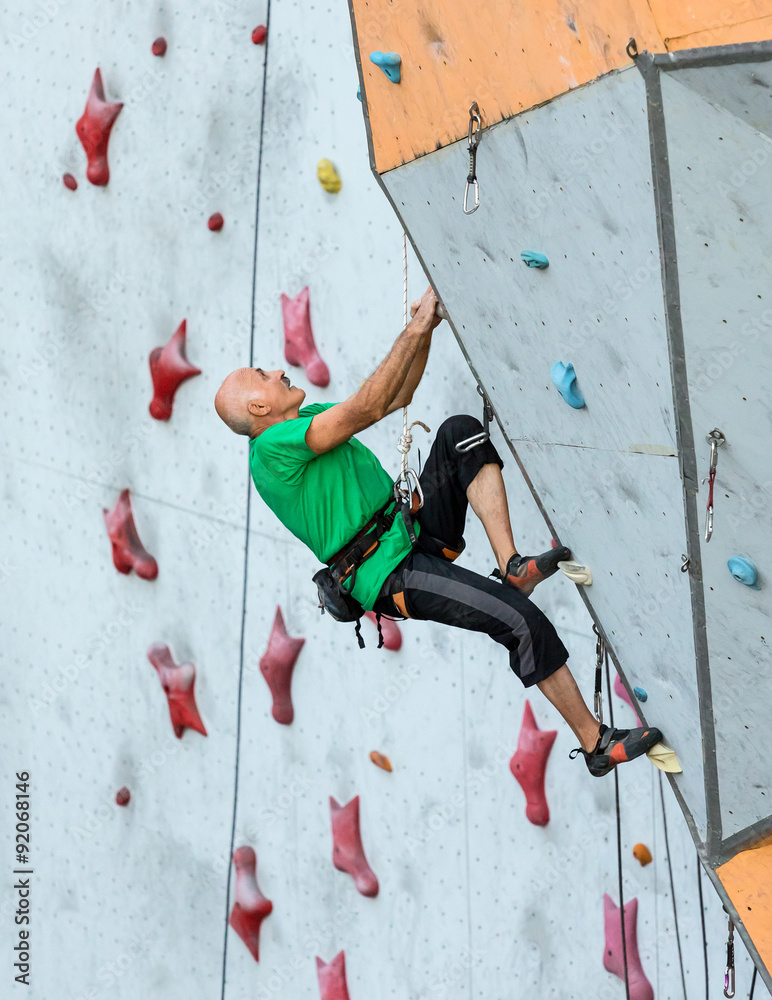Aged Person Practicing Extreme Sport Elderly Male Climber Makes Hard Move and Looking High Up on Outdoor Climbing Wall Sport Competitions Aged Person Practicing Extreme Sport Elderly Male Climber Makes Hard Move and Looking High Up on Outdoor Climbing Wall Sport Competitions