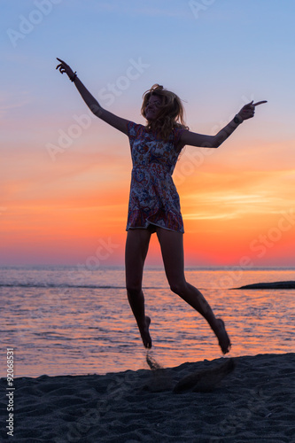 Beautiful young woman on beach at sunset
