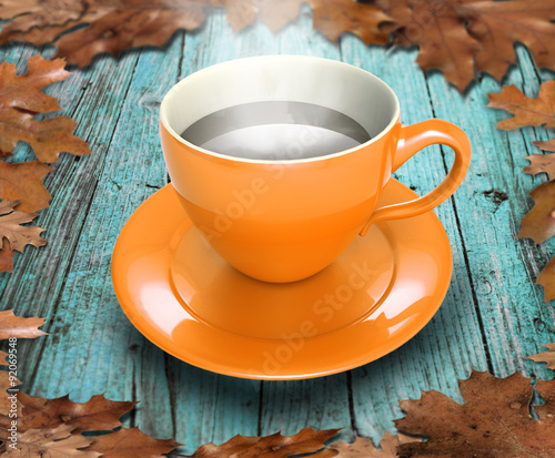 cup of coffee on the table with leaves in autumn