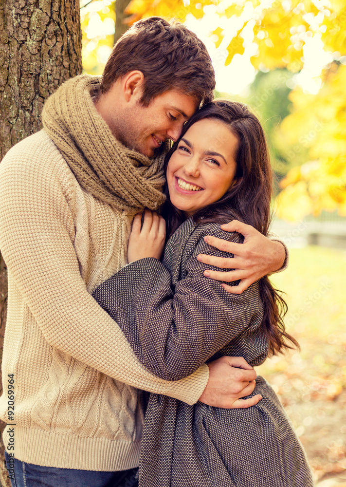 Fototapeta premium smiling couple hugging in autumn park