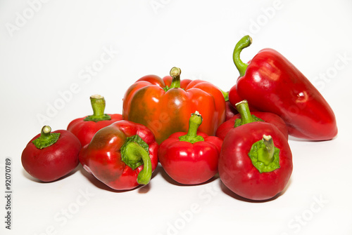 Many ripe red peppers on over white