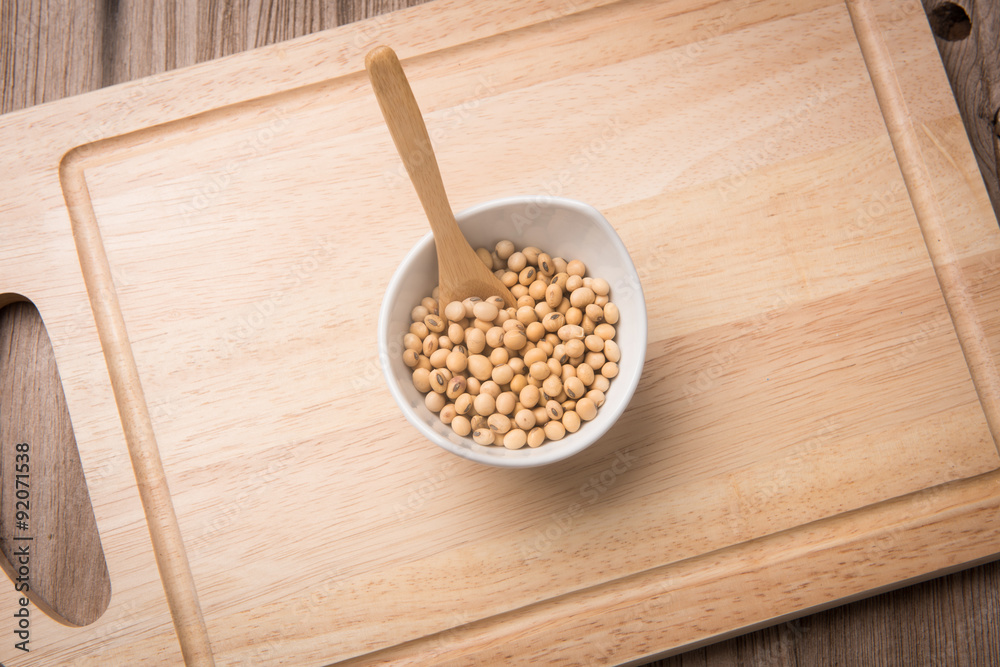 Soybeans in white ceramic bowl on wood block Soybeans in white ceramic bowl on wood block