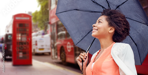 Photography happy african woman with umbrella in london city