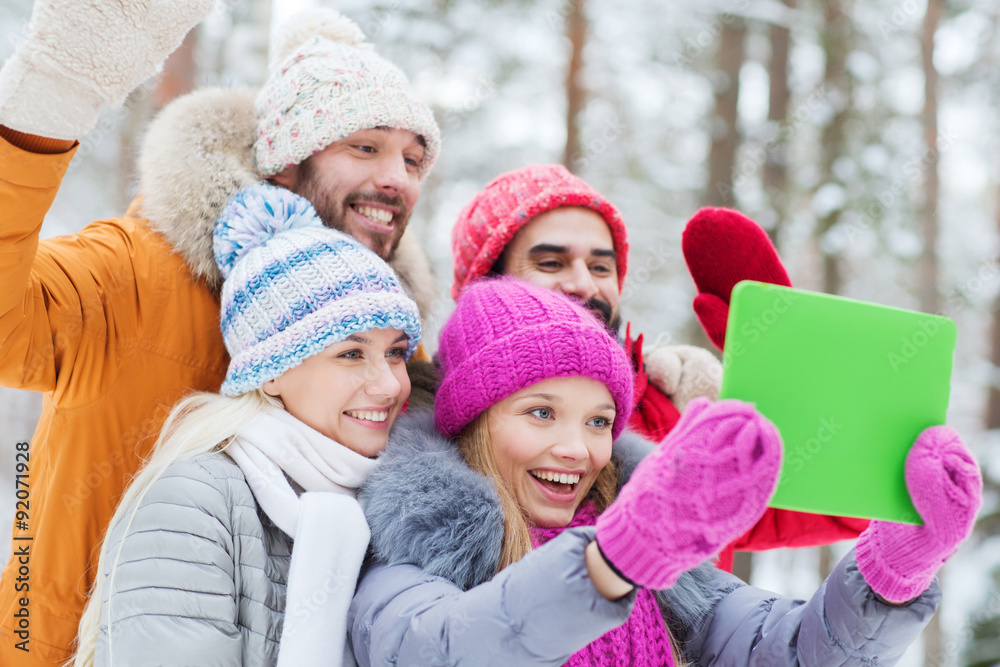 smiling friends with tablet pc in winter forest smiling friends with tablet pc in winter forest