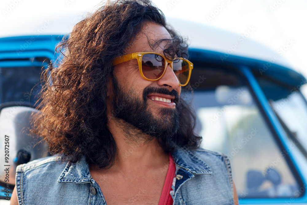 smiling young hippie man over minivan car smiling young hippie man over minivan car
