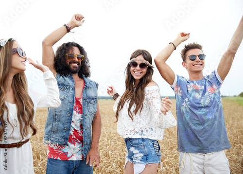 happy young hippie friends dancing outdoors