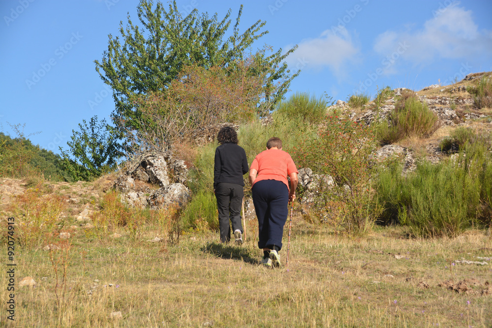 mujeres subiendo por la ladera de una montaña