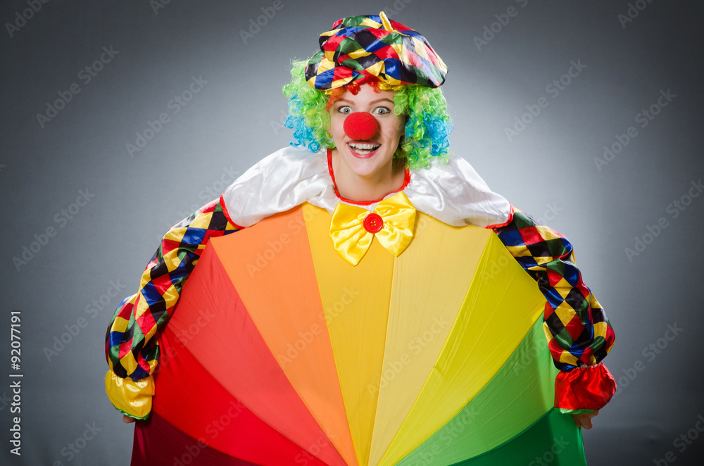 Clown with umbrella in funny concept Clown with umbrella in funny concept