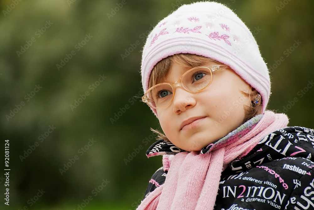 cute child girl in glasses sits on a Park bench cute child girl in glasses sits on a Park bench
