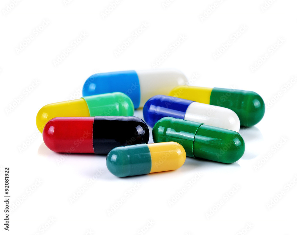 Colored pills, tablets and capsules on a white background Colored pills, tablets and capsules on a white background