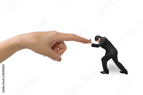 Small businessman pushing against big hand forefinger