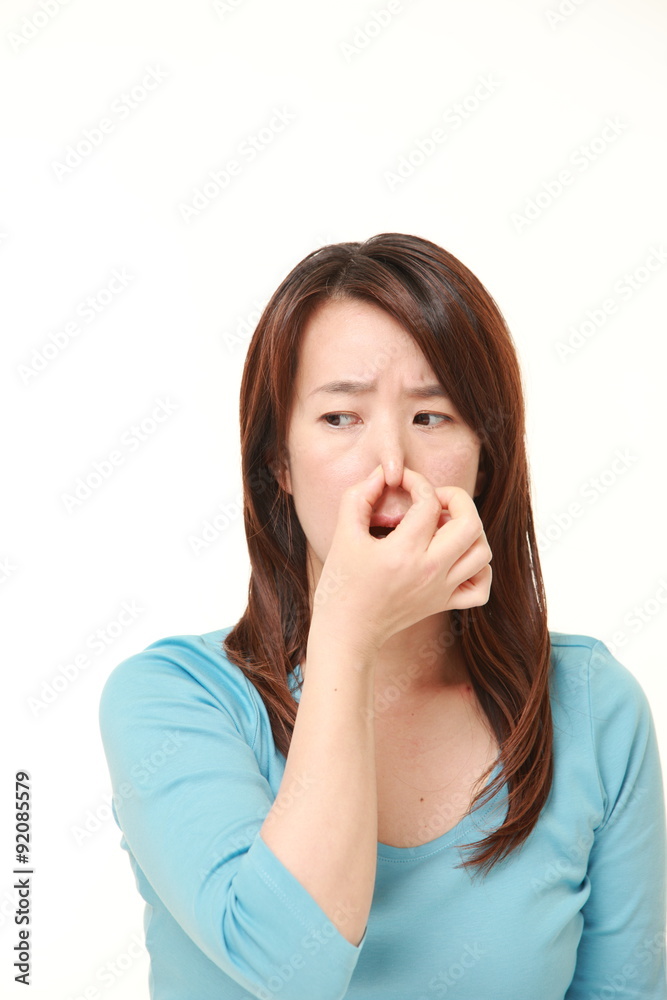 Japanese woman holding her nose because of a bad smell Japanese woman holding her nose because of a bad smell
