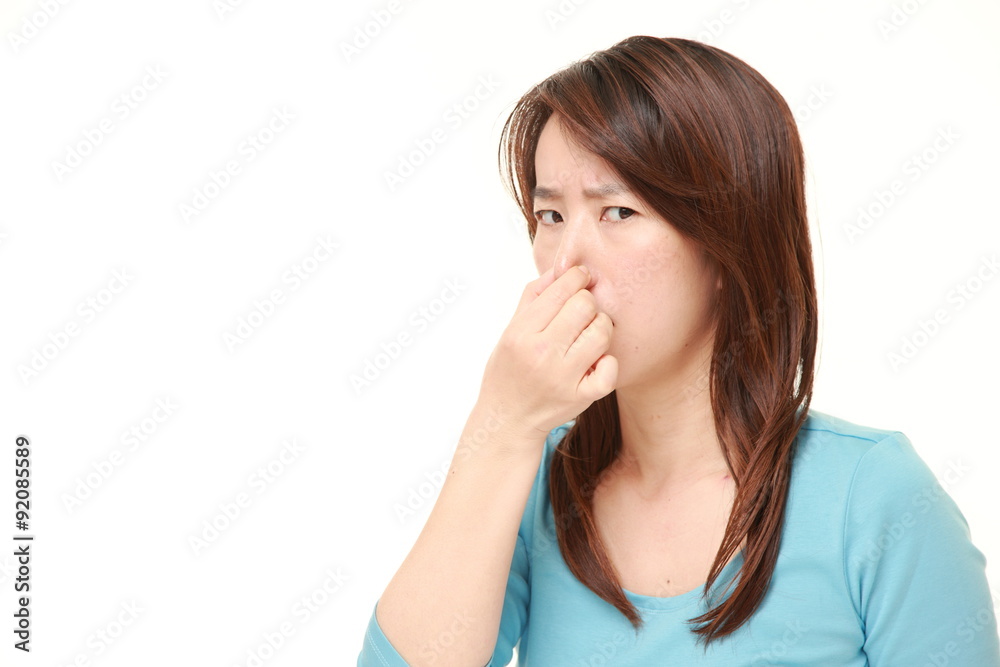 Japanese woman holding her nose because of a bad smell Japanese woman holding her nose because of a bad smell