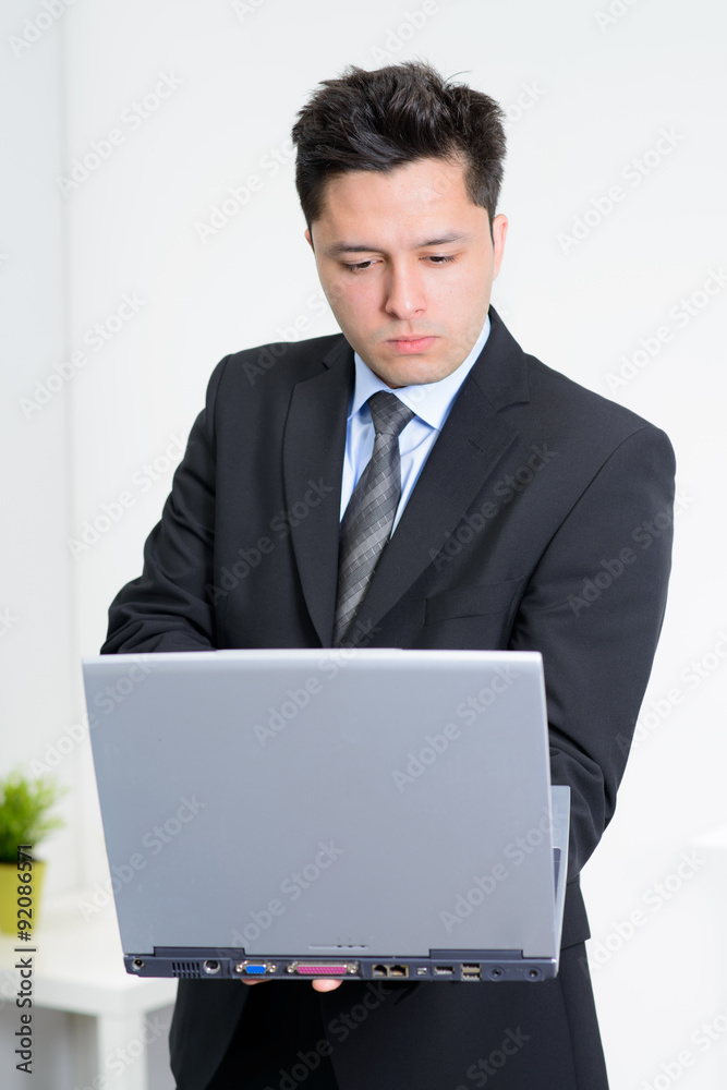 Young Businessman working at laptop standing Young Businessman working at laptop standing