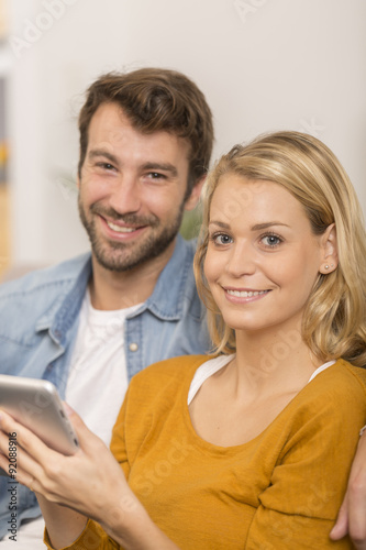 young couple using digital tablet at home