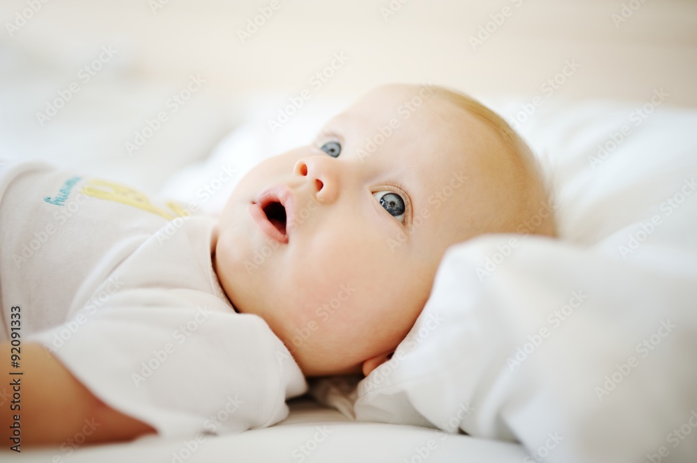 portrait of baby with blue eyes. A child resting on a bed portrait of baby with blue eyes. A child resting on a bed