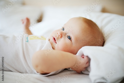 portrait of baby with blue eyes. A child resting on a bed