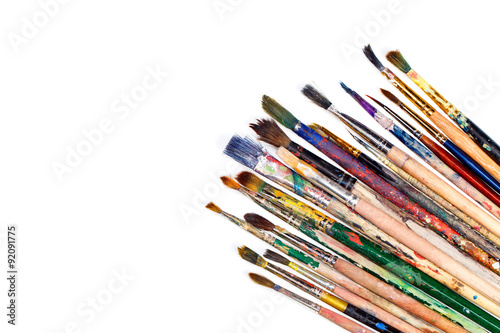 Big set of artist dirty paint brushes on white background with much space for text. Isolated image. 