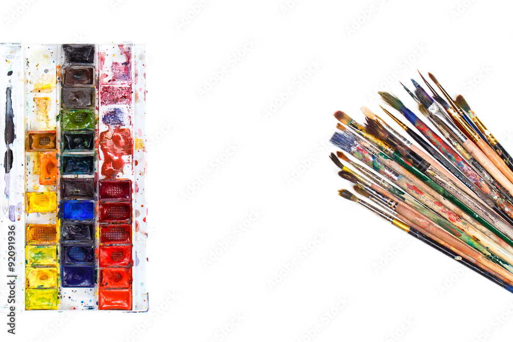 Used water-color paint-box and dirty artist paint brushes. Top view. Isolated image with space for your text