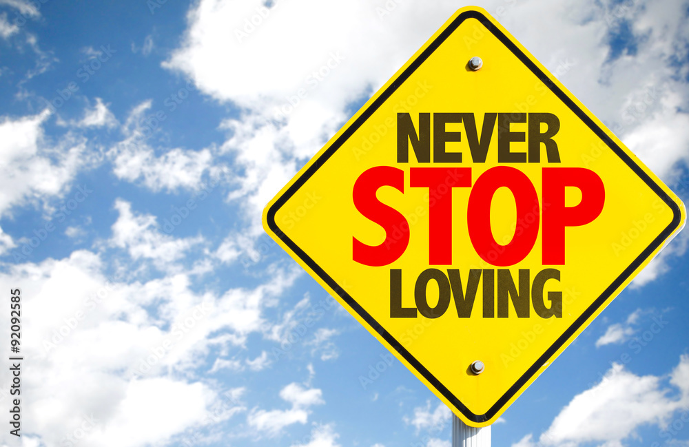 Naklejka premium Never Stop Loving sign with sky background