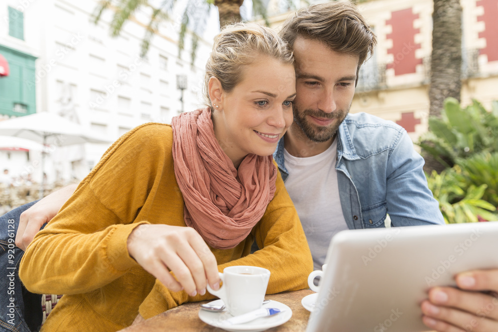 young couple using a digital tablet at a bar terrace young couple using a digital tablet at a bar terrace