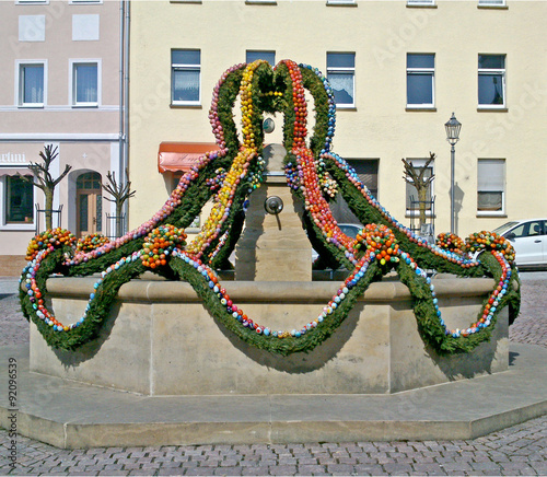 Osterbrunnen/Auf dem Marktplatz einer Kleinstadt in Thüringen ist zu Ostern der Brunnen mit vielen bunten Ostereiern geschmückt