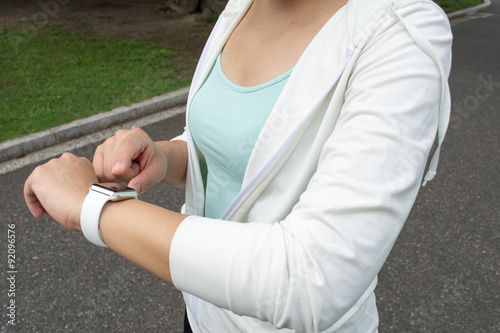 Young Asian fitness woman runner setting her smartwatch