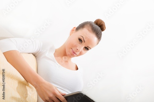 Young woman with a Tablet PC on the Sofa