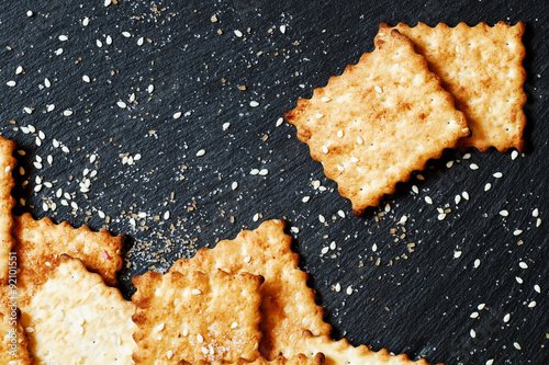 Sweet crackers, sesame, sugar grains on a dark background, top v