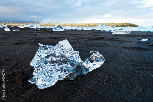 Melting of icebergs at black beach in Jokulsarlon glacier lagoon