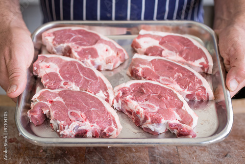 Butcher holding a Tray of lamb steaks