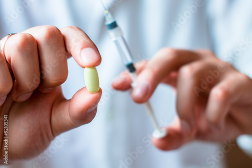 Syringe, pills or capsules, medical injection in hand, palm