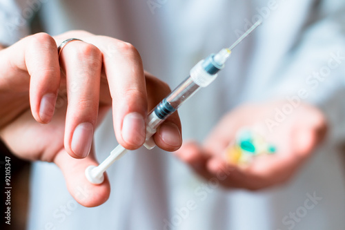 Syringe  pills or capsules  medical injection in hand  palm