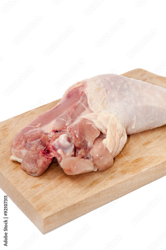 Chicken drumstick on the wooden board over white background