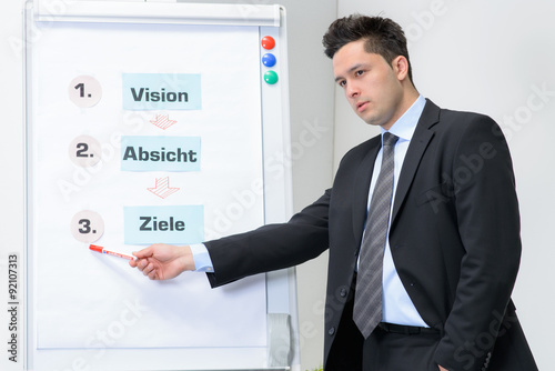 Businessman in meeting pointed at board