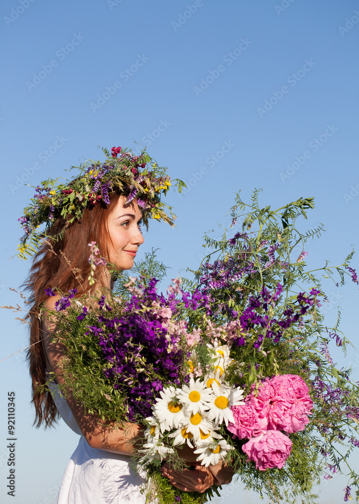 Naklejka premium Portrait of Young beautiful Woman with Bouquet, wearing a Wreath