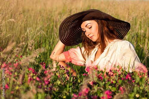 Portrait of a romantic young woman in hat on a flowers field, ou © IULIIA AZAROVA