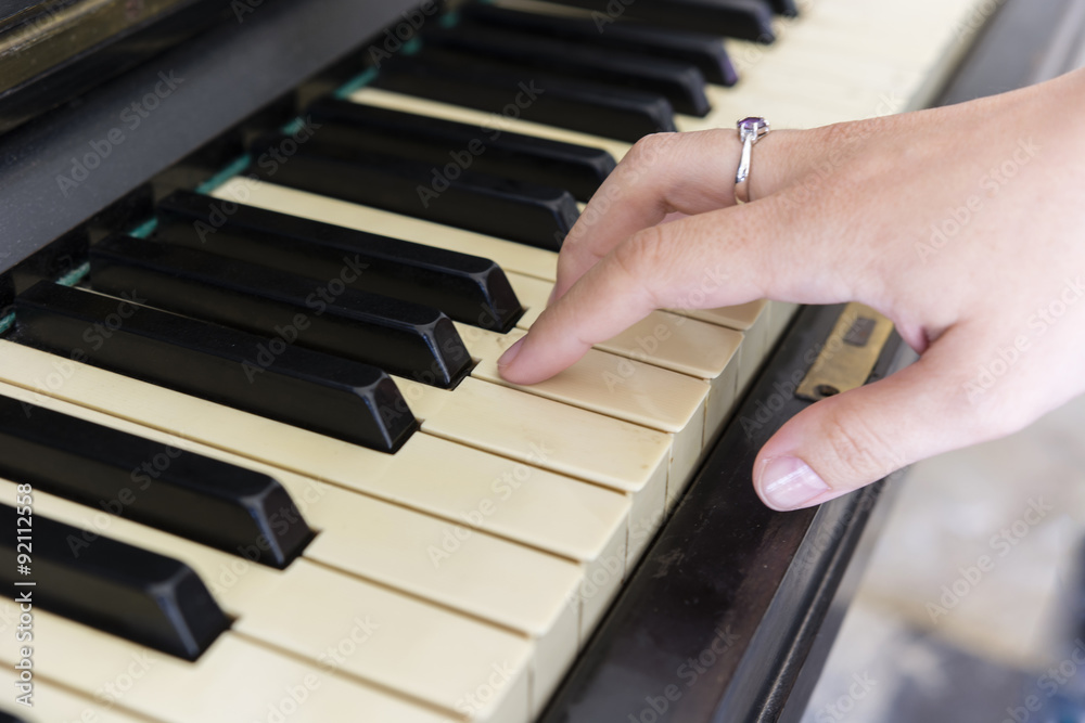Obraz premium Woman's hand playing the piano detail