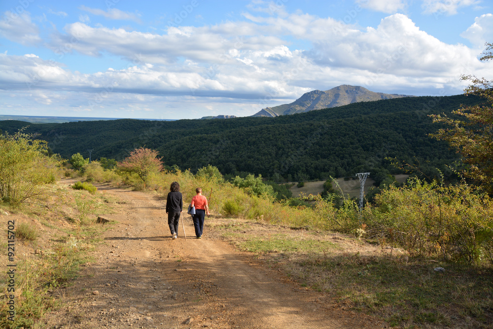 mujeres caminando por un camino de montaña