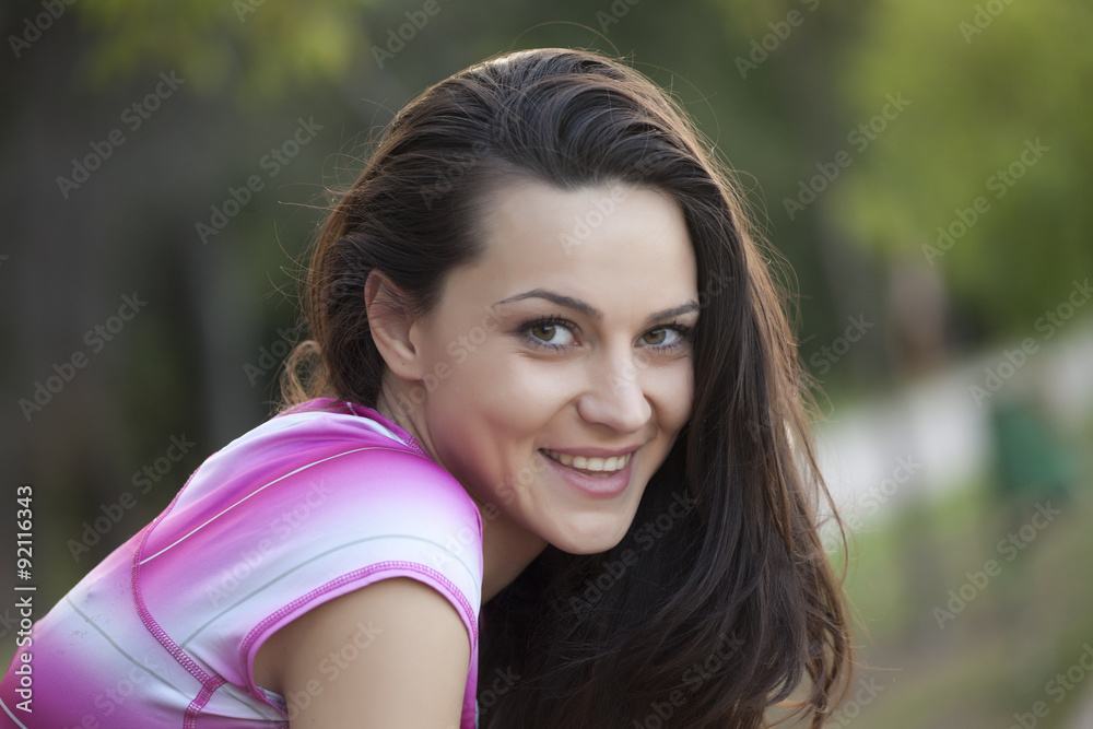smiling young woman posing in the park smiling young woman posing in the park