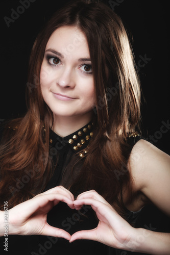 teen girl doing heart shape love symbol with hands