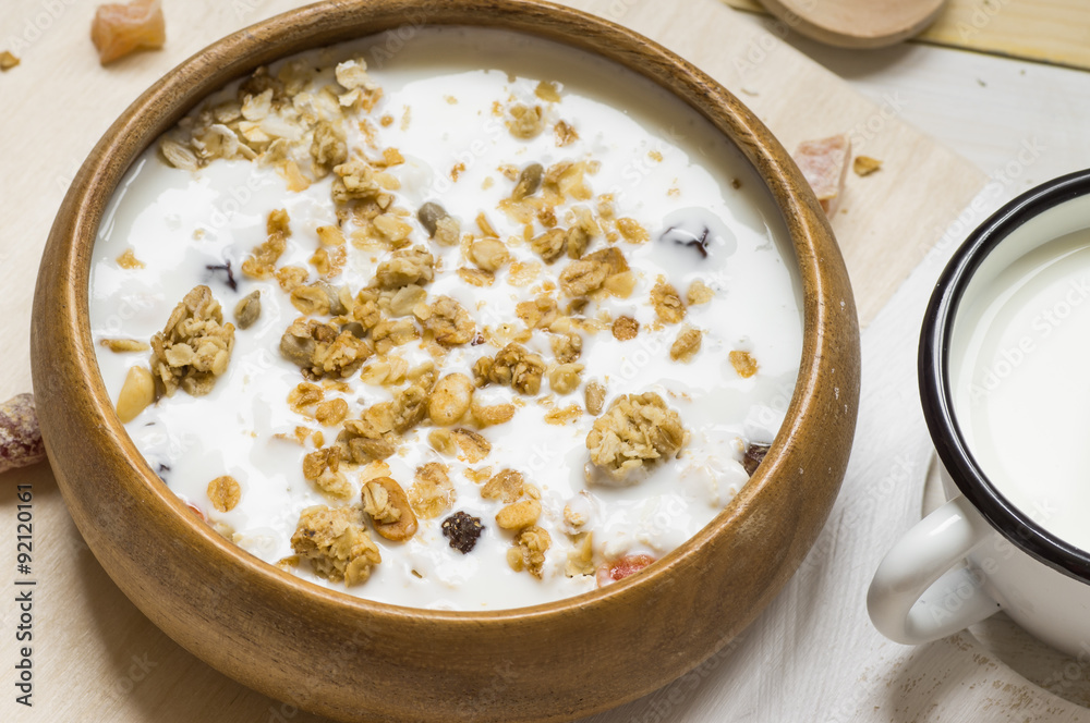 Muesli with milk in a rustic wooden bowl Muesli with milk in a rustic wooden bowl