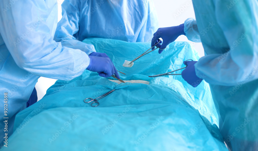 Team of surgeon in uniform perform operation on a patient at Team of surgeon in uniform perform operation on a patient at